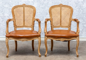 SOLD A stylish pair of carved limed wood, tan leather and caned back fauteuils, French circa 1920