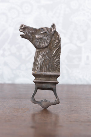 A vintage Spanish metal bottle opener in the form of a horses head