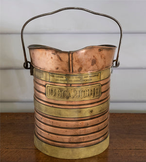 SOLD A copper and brass banded vessel with steel handle embossed 
